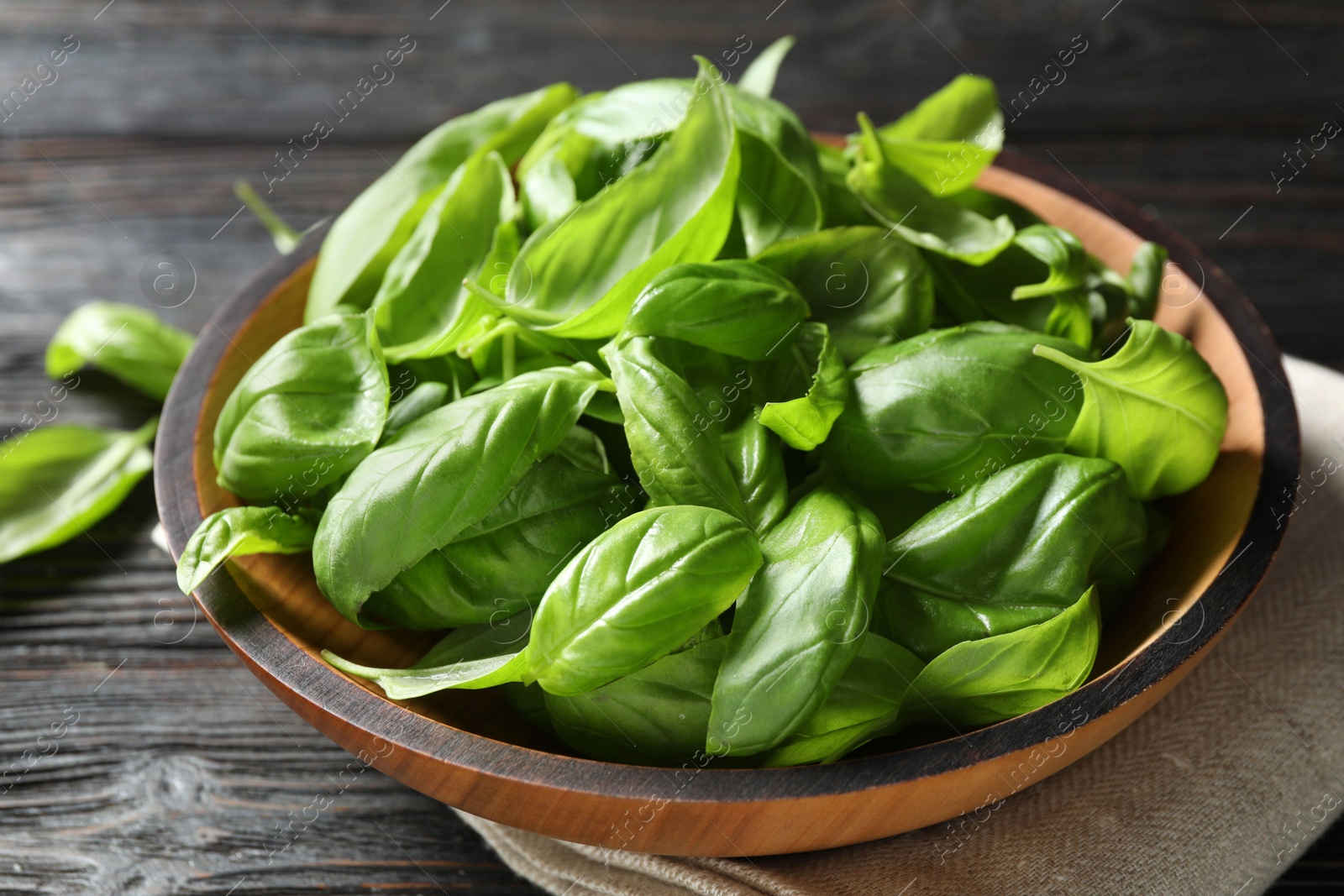 Photo of Fresh green basil on black wooden table, closeup