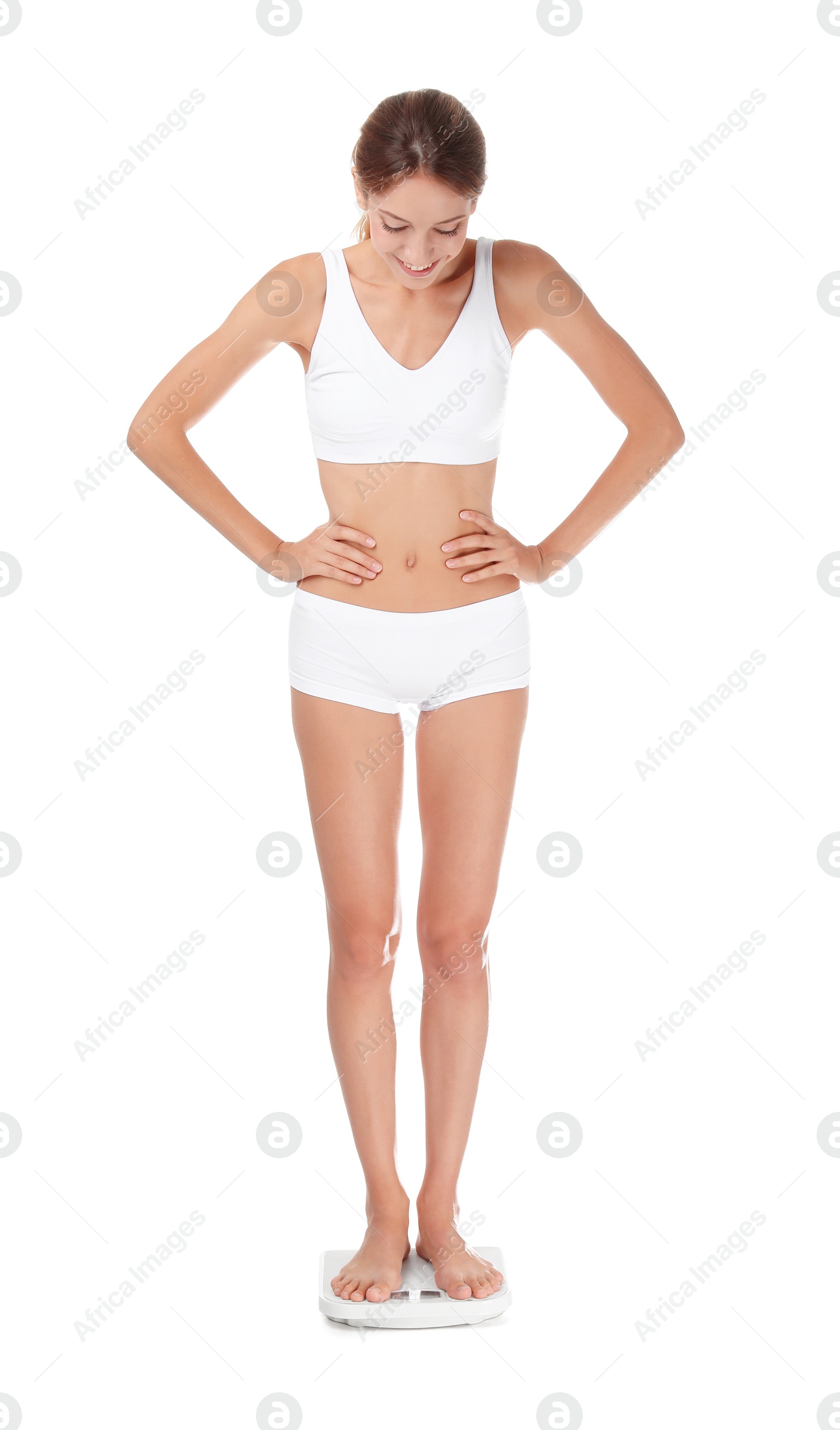 Photo of Happy young woman satisfied with her diet results using bathroom scales on white background