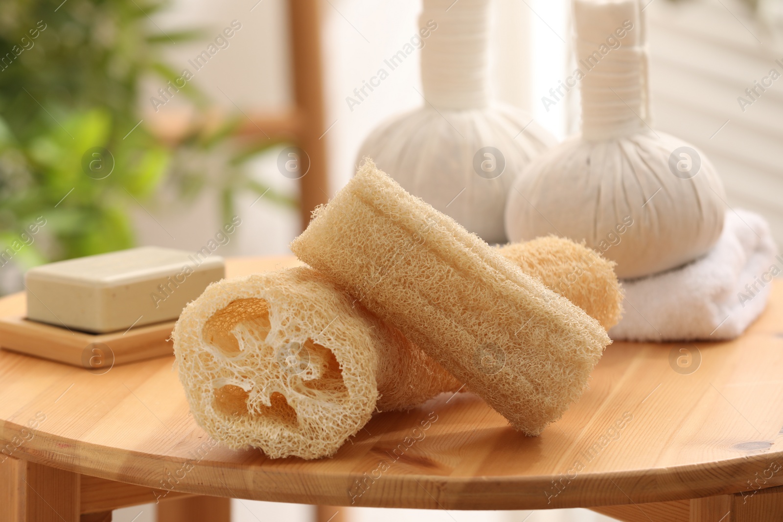 Photo of Loofah sponges on wooden table indoors, closeup