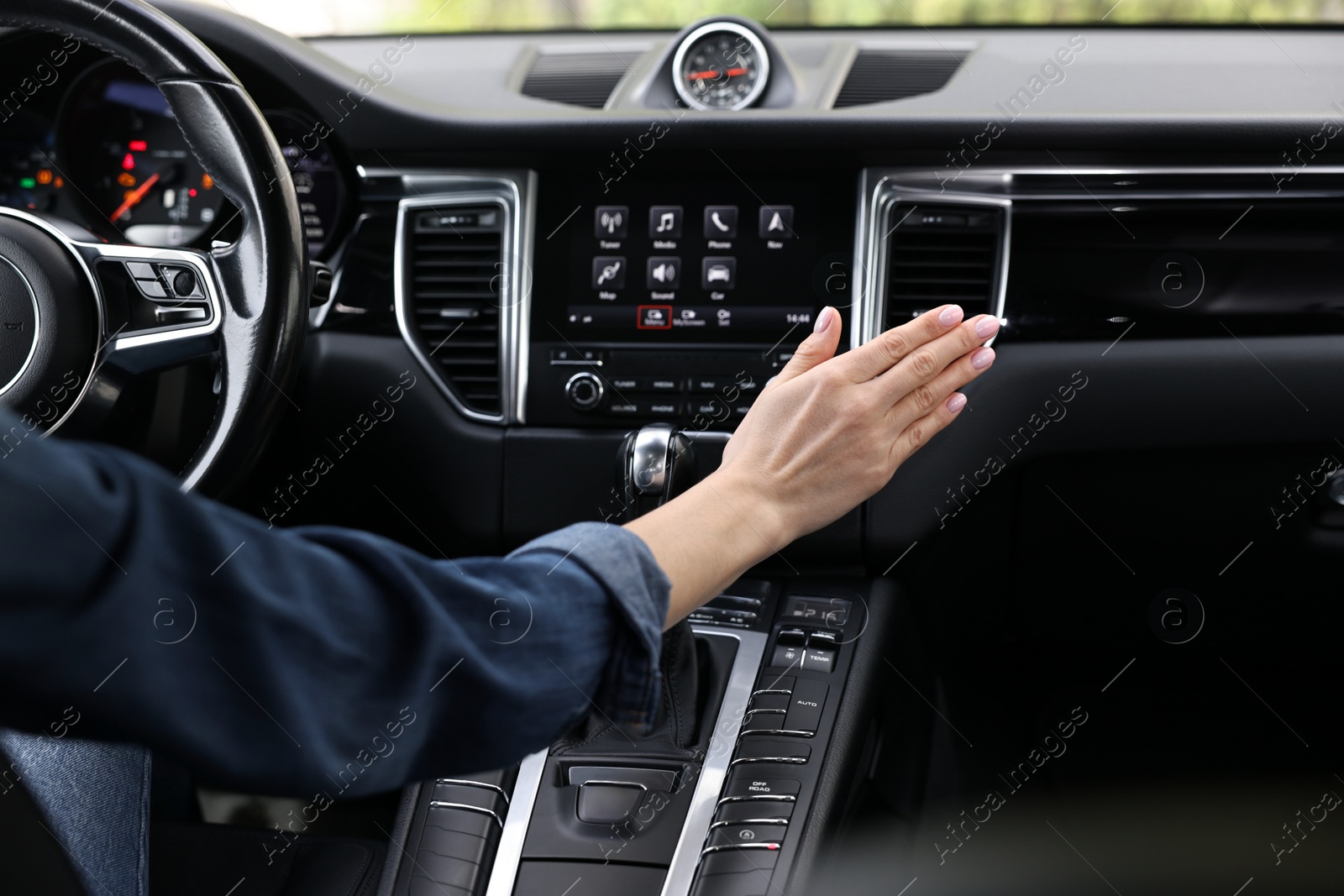 Photo of Woman checking air conditioner in her car, closeup