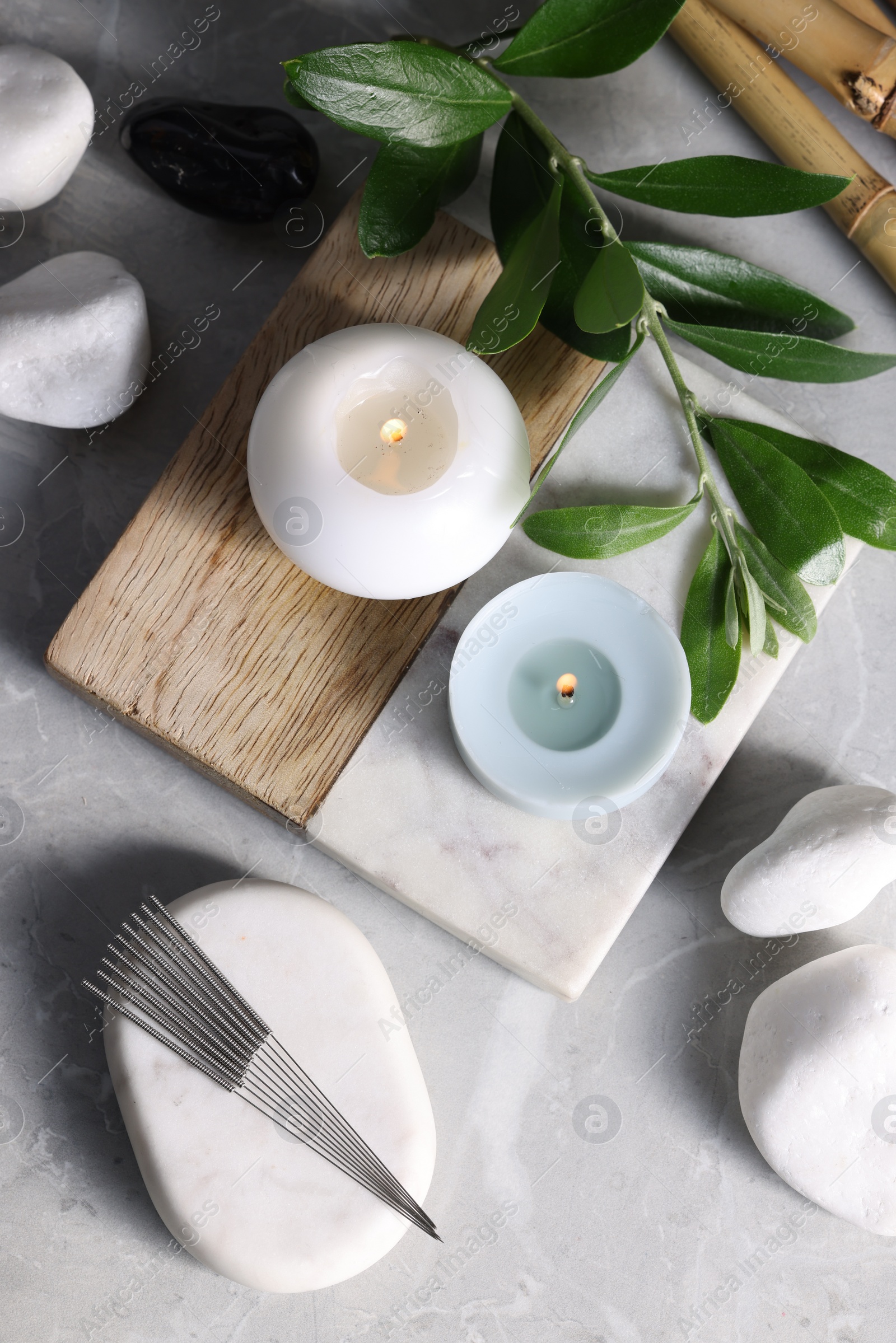 Photo of Flat lay composition with acupuncture needles on light grey marble table