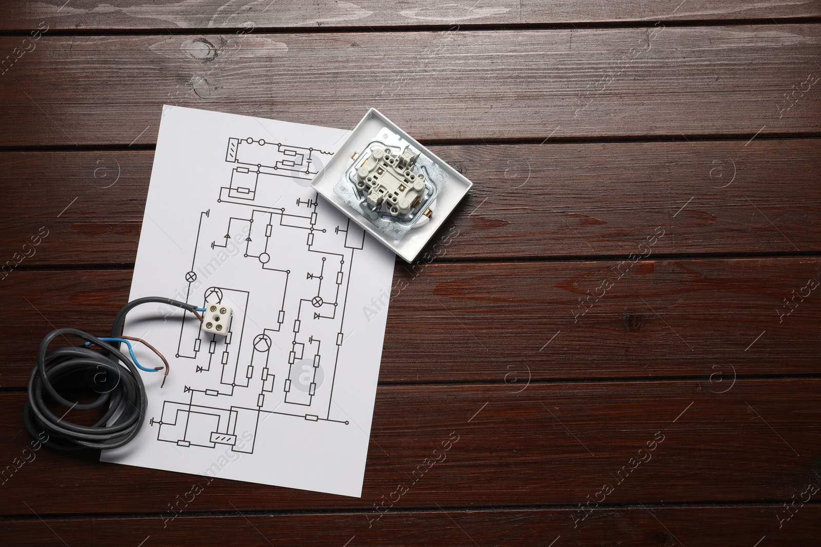 Photo of Wiring diagram, wires and disassembled light switch on wooden table, flat lay. Space for text