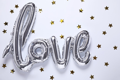 Silver balloon in shape of word LOVE on white background, top view
