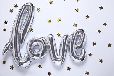 Photo of Silver balloon in shape of word LOVE on white background, top view