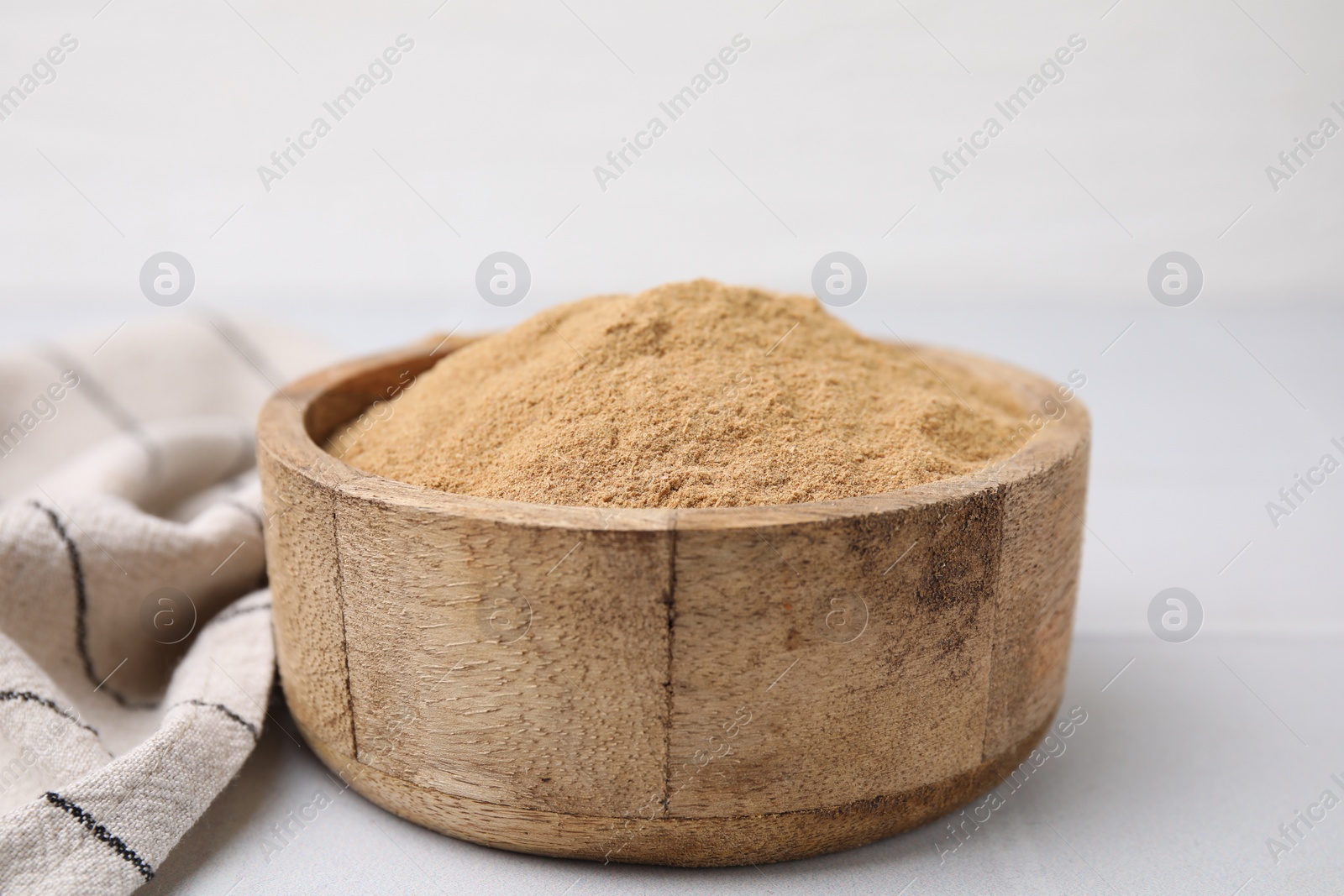 Photo of Dietary fiber. Psyllium husk powder in bowl on white table, closeup