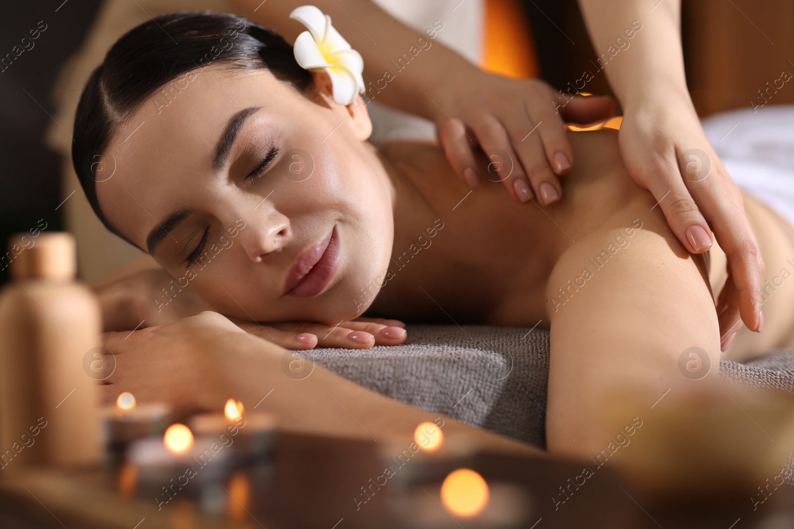 Photo of Spa therapy. Beautiful young woman lying on table during massage in salon