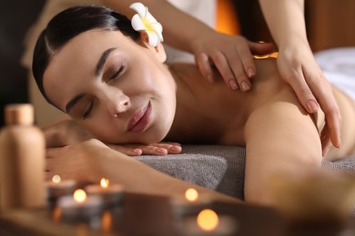 Photo of Spa therapy. Beautiful young woman lying on table during massage in salon