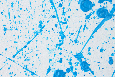 Photo of Blue paint splashes on white canvas as background. Art and creativity