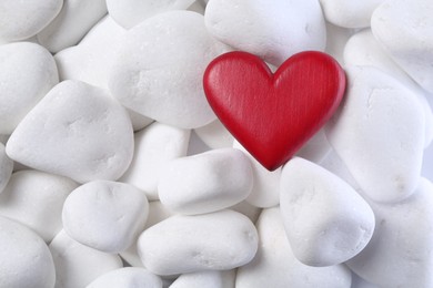 Decorative heart on white pebble stones, top view