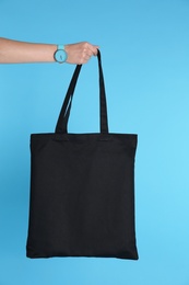 Photo of Woman holding eco bag on color background. Mock up for design