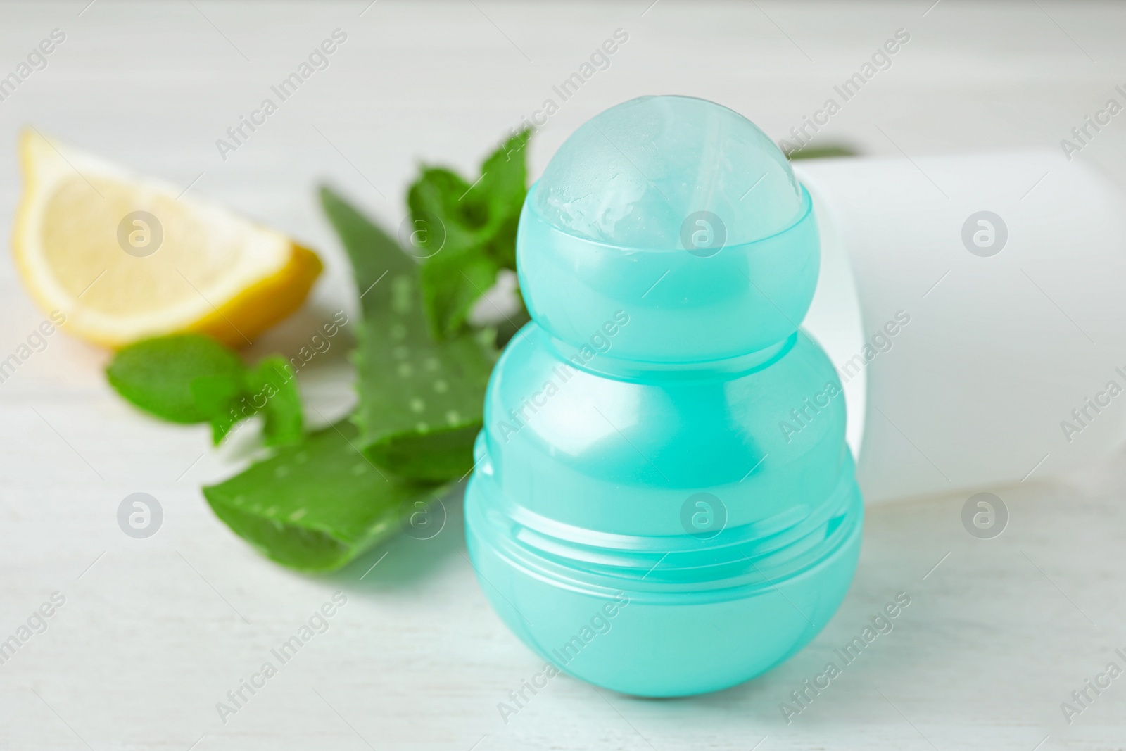 Photo of Female roll-on deodorant, lemon and aloe on white wooden table