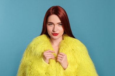 Photo of Stylish woman with red dyed hair on light blue background