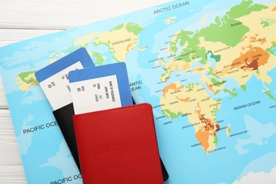 Photo of Honeymoon concept. Plane tickets, passports and world map on white wooden table, top view