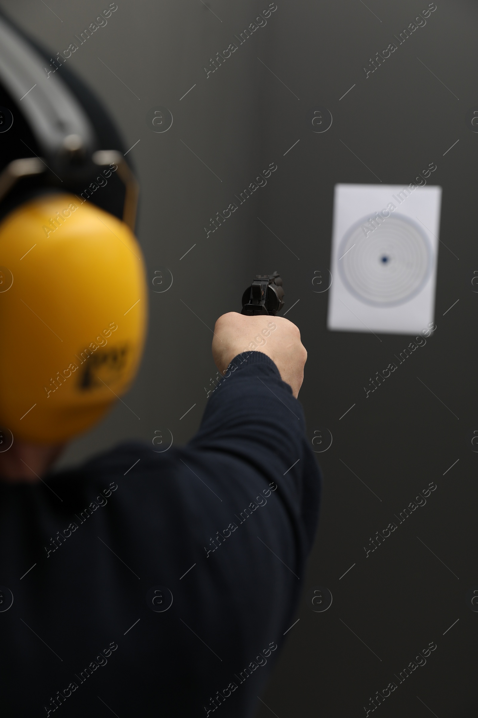 Photo of Man aiming at shooting target indoors, closeup