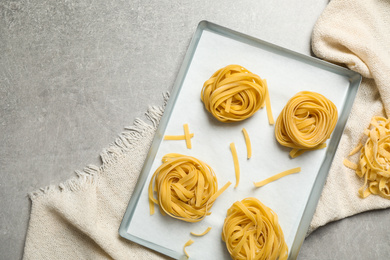 Photo of Tagliatelle pasta on light table, flat lay