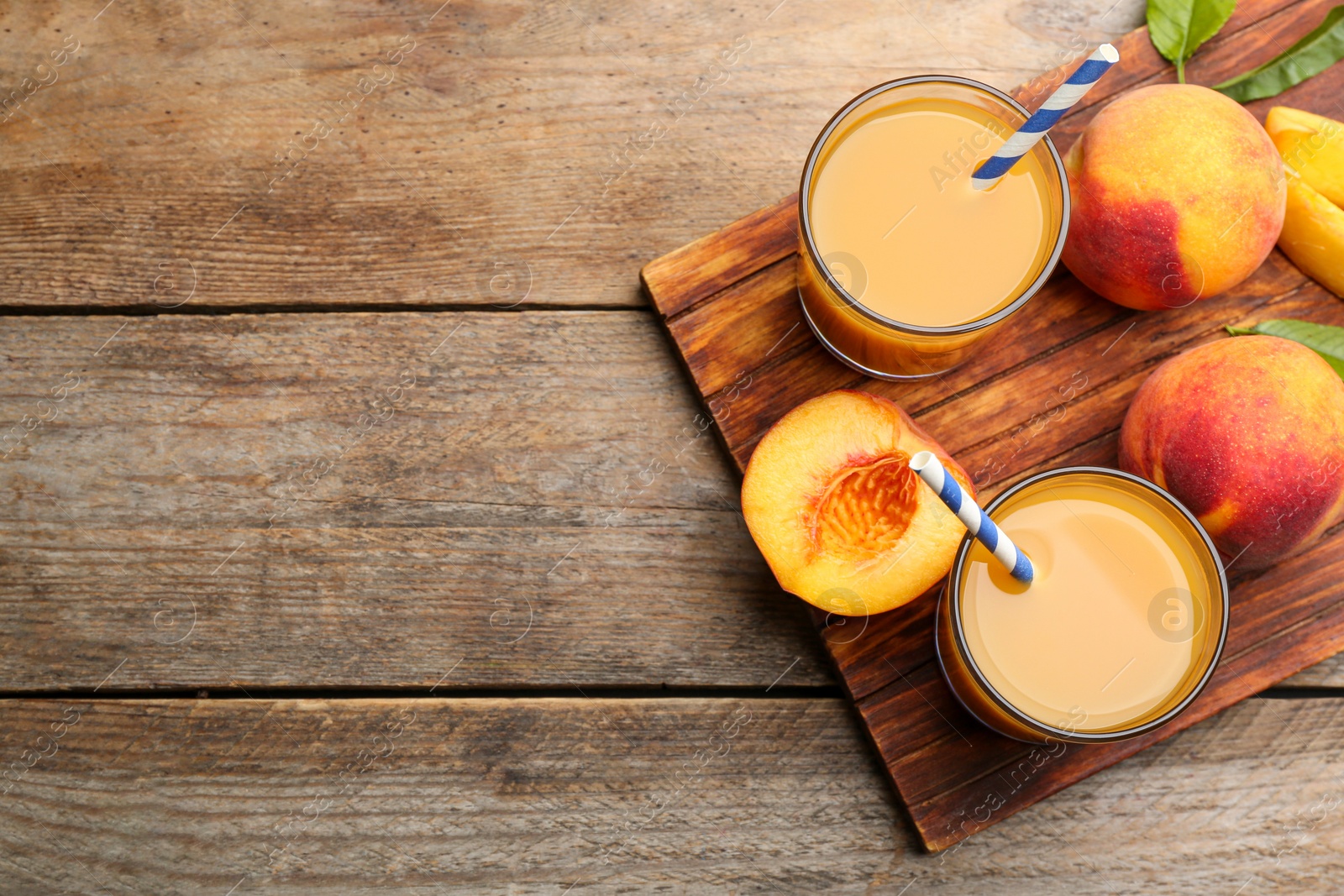 Photo of Natural peach juice and fresh fruits on wooden table, flat lay. Space for text