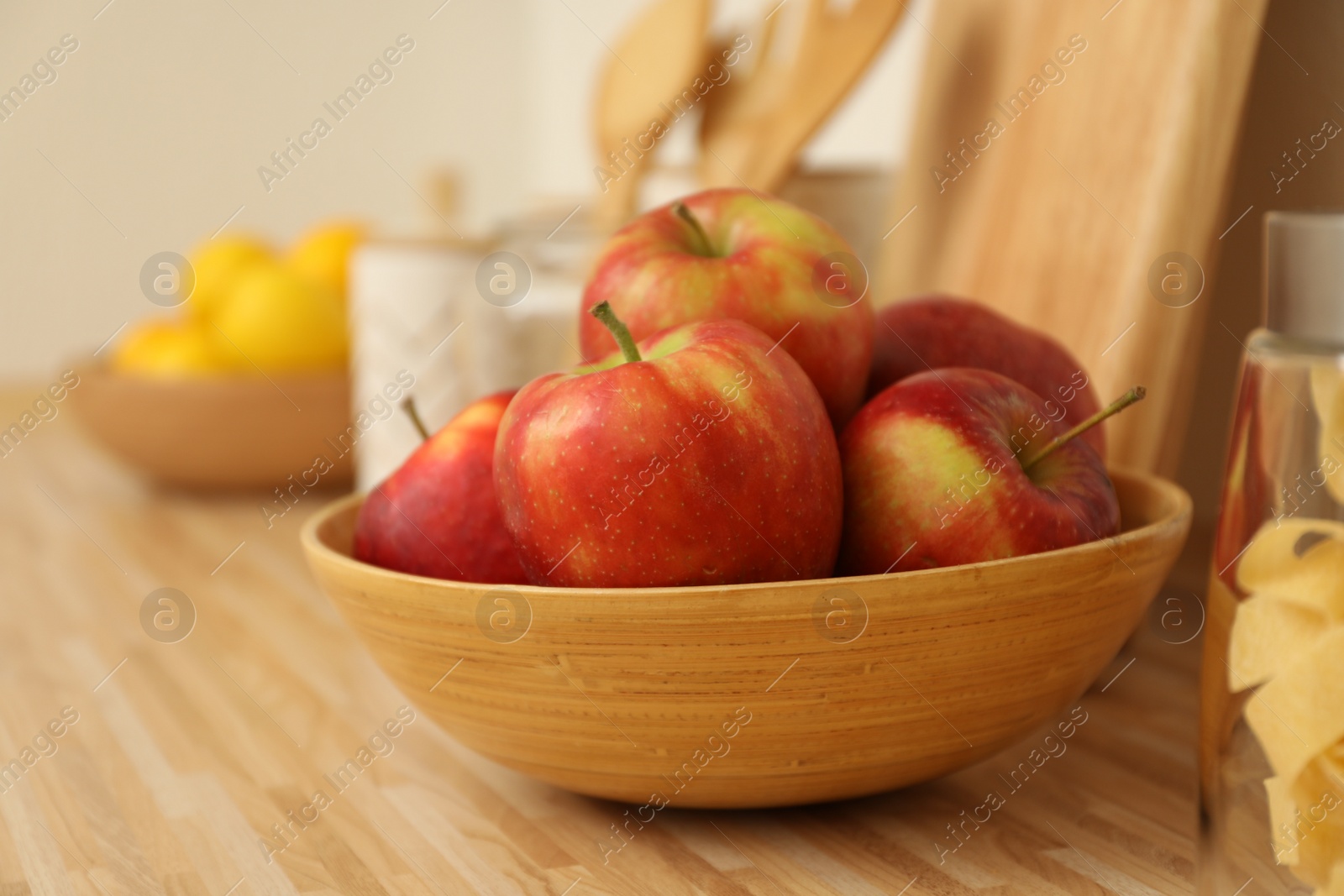 Photo of Apples in bowl on wooden countertop in kitchen. Interior element