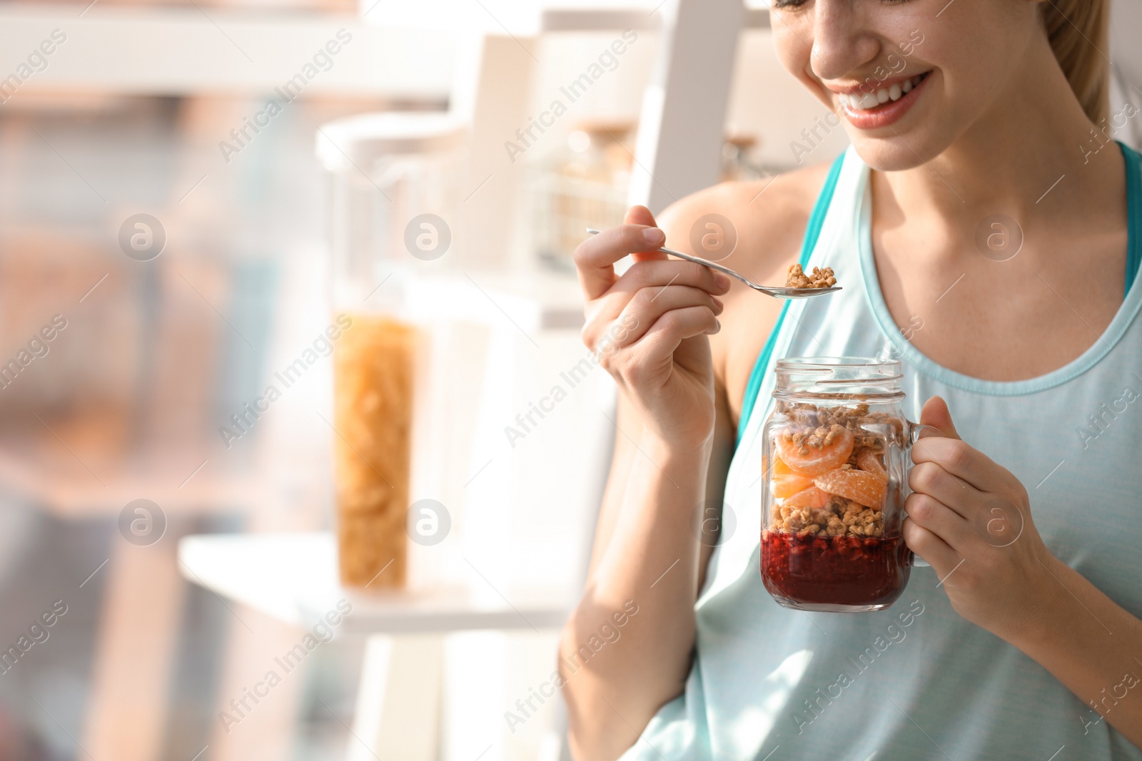 Photo of Young woman in fitness clothes having healthy breakfast at home, closeup. Space for text