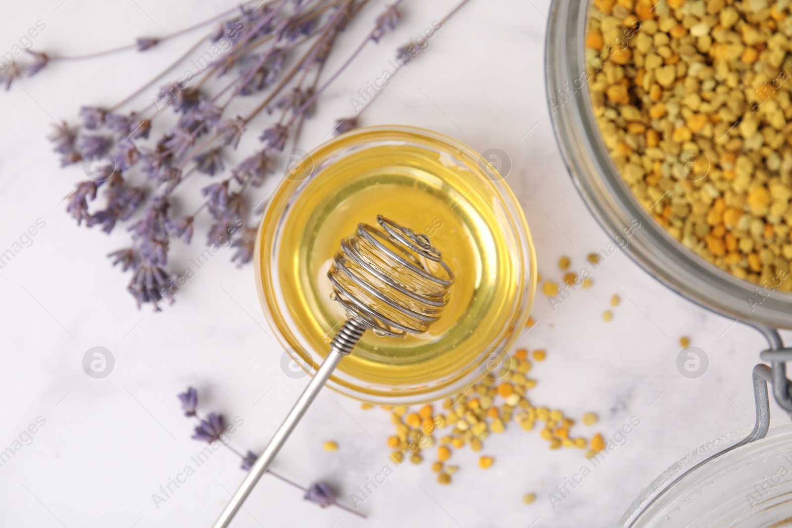 Photo of Fresh honey in bowl, dipper, bee pollen granules and lavender on light table, flat lay
