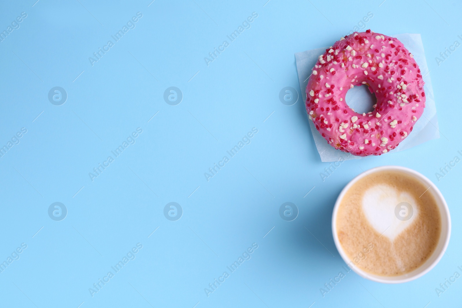 Photo of Tasty frosted donut and cup of coffee on light blue background, flat lay. Space for text
