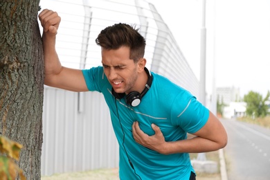 Young man having heart attack while running outdoors
