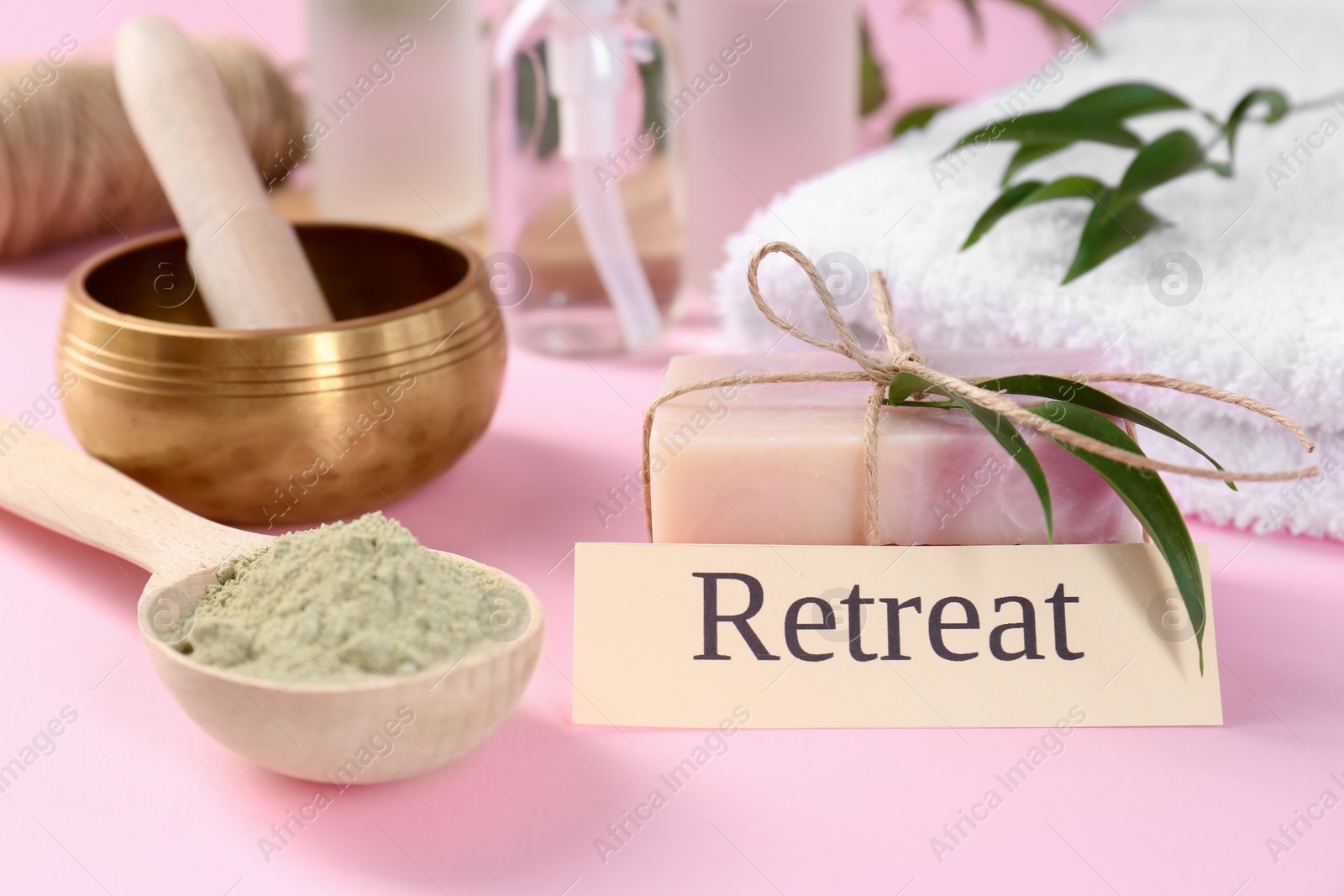 Photo of Card with word Retreat, soap bars, spirulina powder and singing bowl on pink background