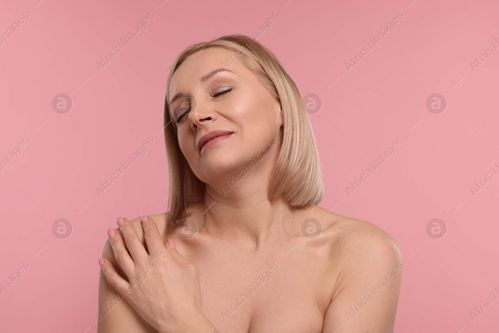 Photo of Beautiful woman touching her neck on pink background