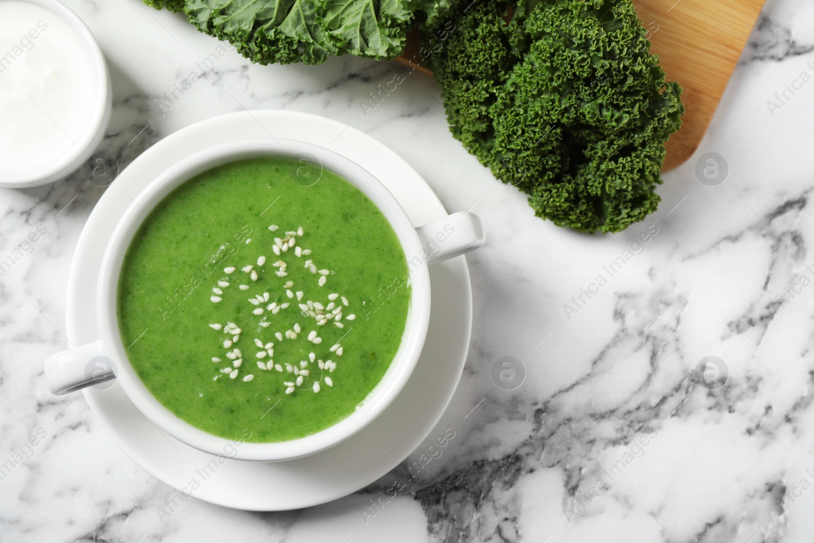 Photo of Tasty kale soup on marble table, flat lay. Space for text