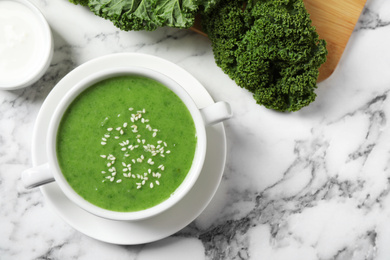 Photo of Tasty kale soup on marble table, flat lay. Space for text
