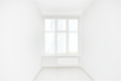 Image of Empty room with white walls and window, blurred view