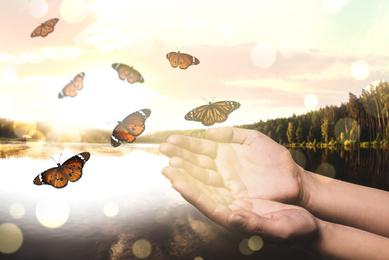 Image of Woman releasing butterflies near lake, closeup. Freedom concept