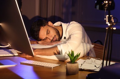 Tired man fell asleep at workplace in office