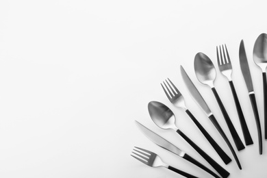 Photo of Forks, knives and spoons on white background