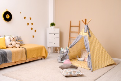 Cozy child room interior with bed, play tent and modern decor elements