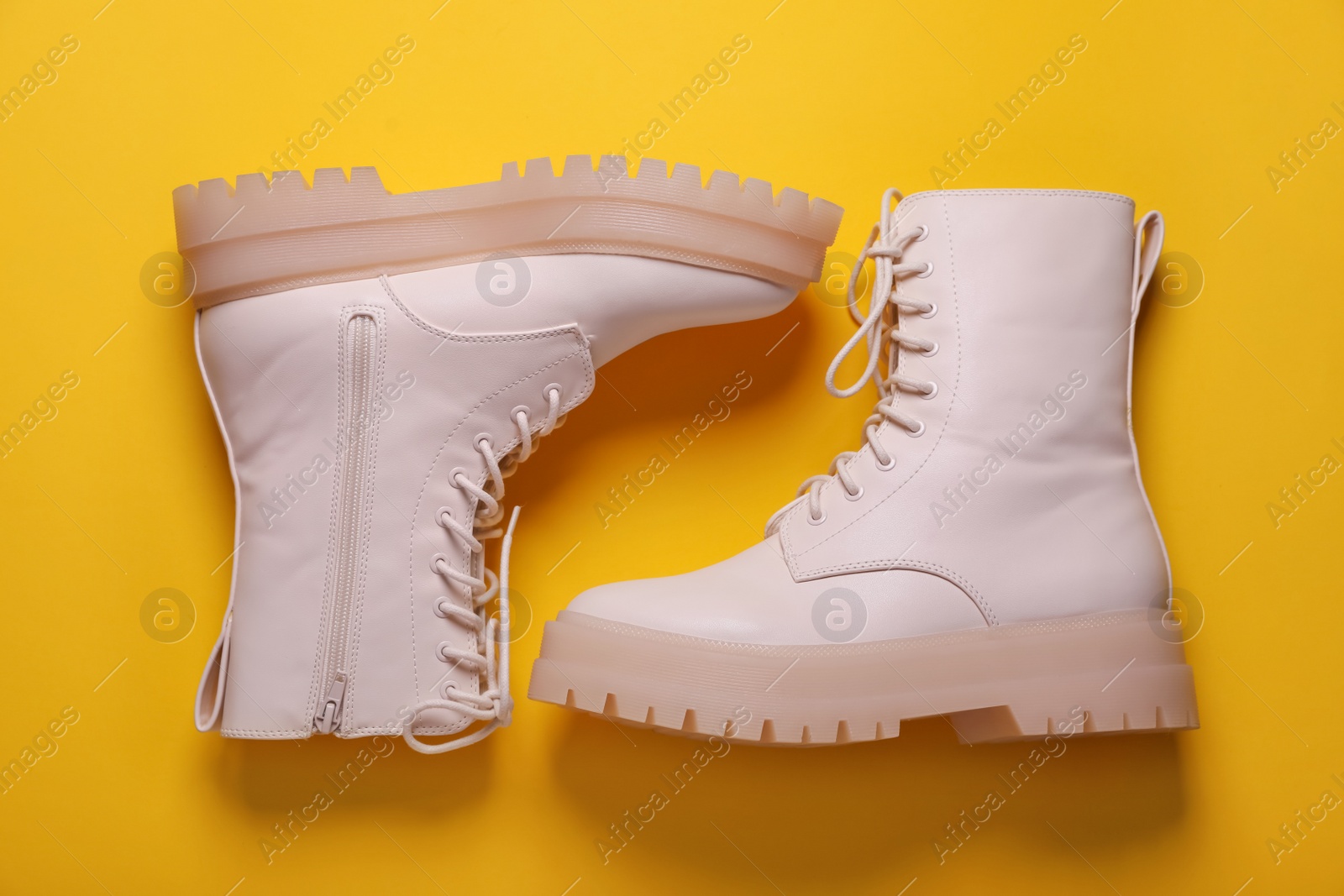 Photo of Pair of stylish shoes on yellow background, flat lay