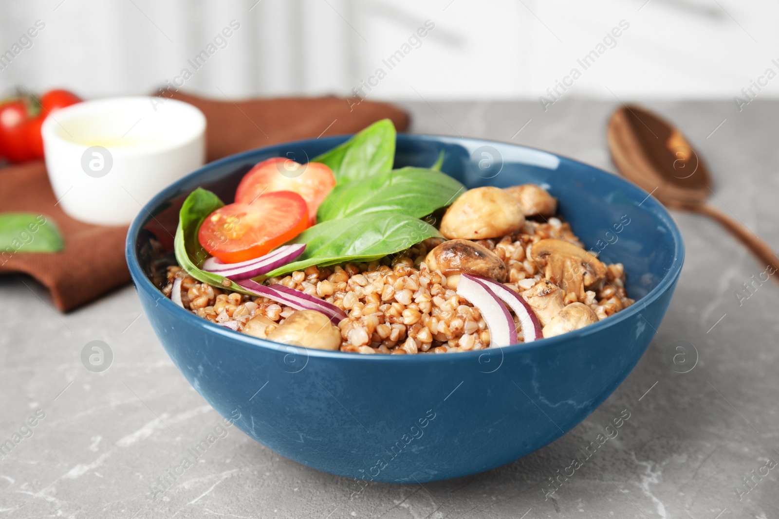 Photo of Tasty buckwheat porridge with vegetables and mushrooms on table indoors