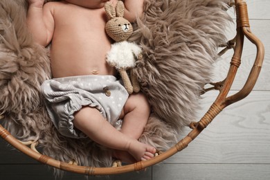 Photo of Cute newborn baby in wicker basket indoors, closeup