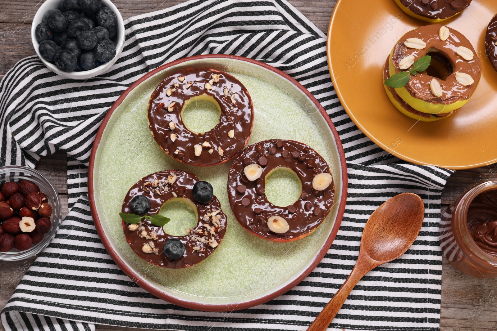 Photo of Fresh apples with nut butters, blueberries, chocolate chips and nuts on table, flat lay