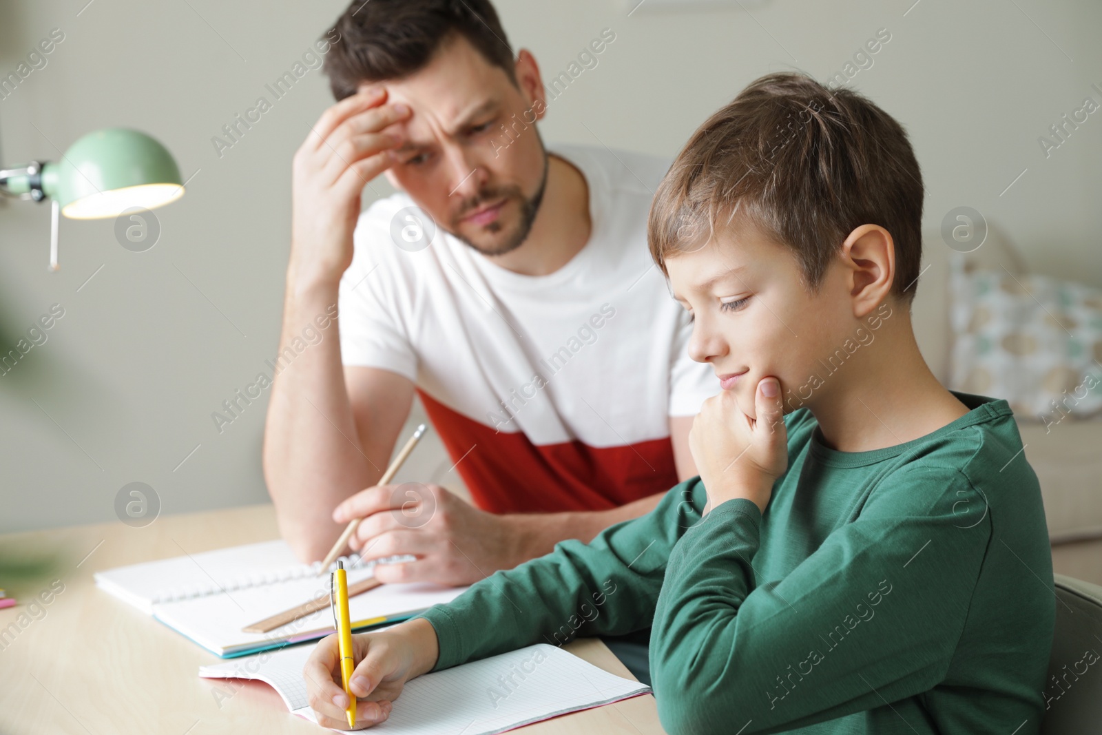 Photo of Dad struggling to help his son with school assignment at home