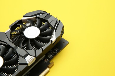 Photo of Computer graphics card on yellow background, closeup. Space for text