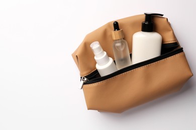 Preparation for spa. Compact toiletry bag with cosmetic products on white background, top view. Space for text