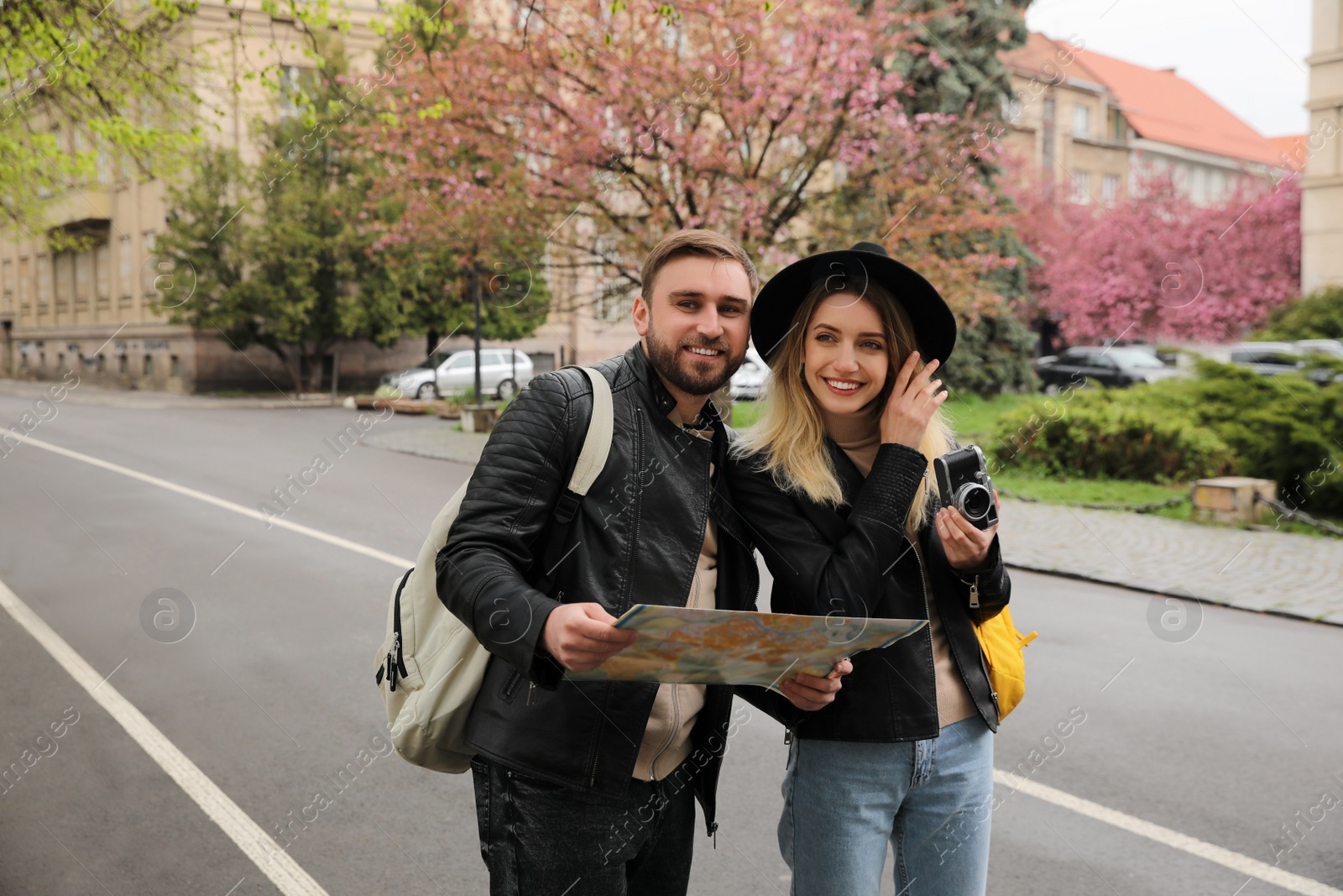 Photo of Couple of tourists with map and camera on city street