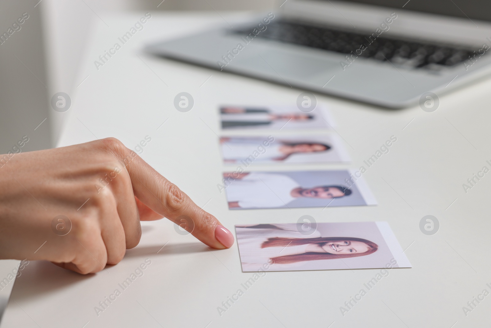 Photo of Human resources manager choosing employee among different applicants at table, closeup