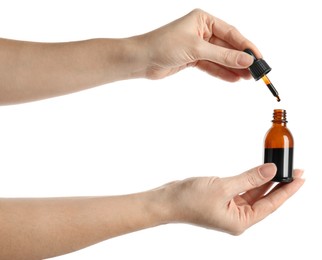 Photo of Woman dripping medical iodine into bottle on white background, closeup