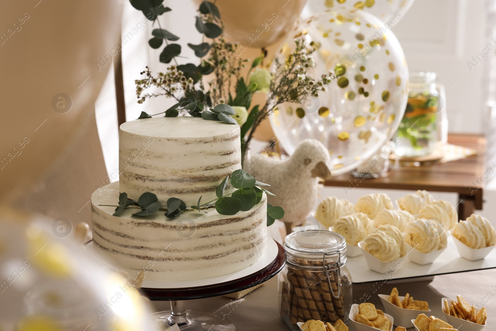 Photo of Beautiful cake and other treats on table in room. Sweet buffet