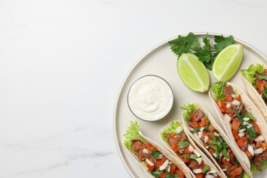 Photo of Delicious tacos with meat and vegetables served on white marble table, top view. Space for text