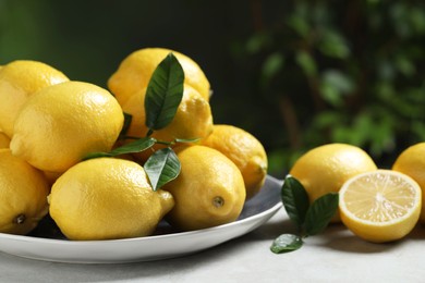 Fresh lemons and green leaves on table outdoors