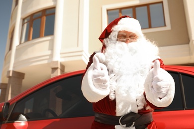 Photo of Authentic Santa Claus near modern car outdoors