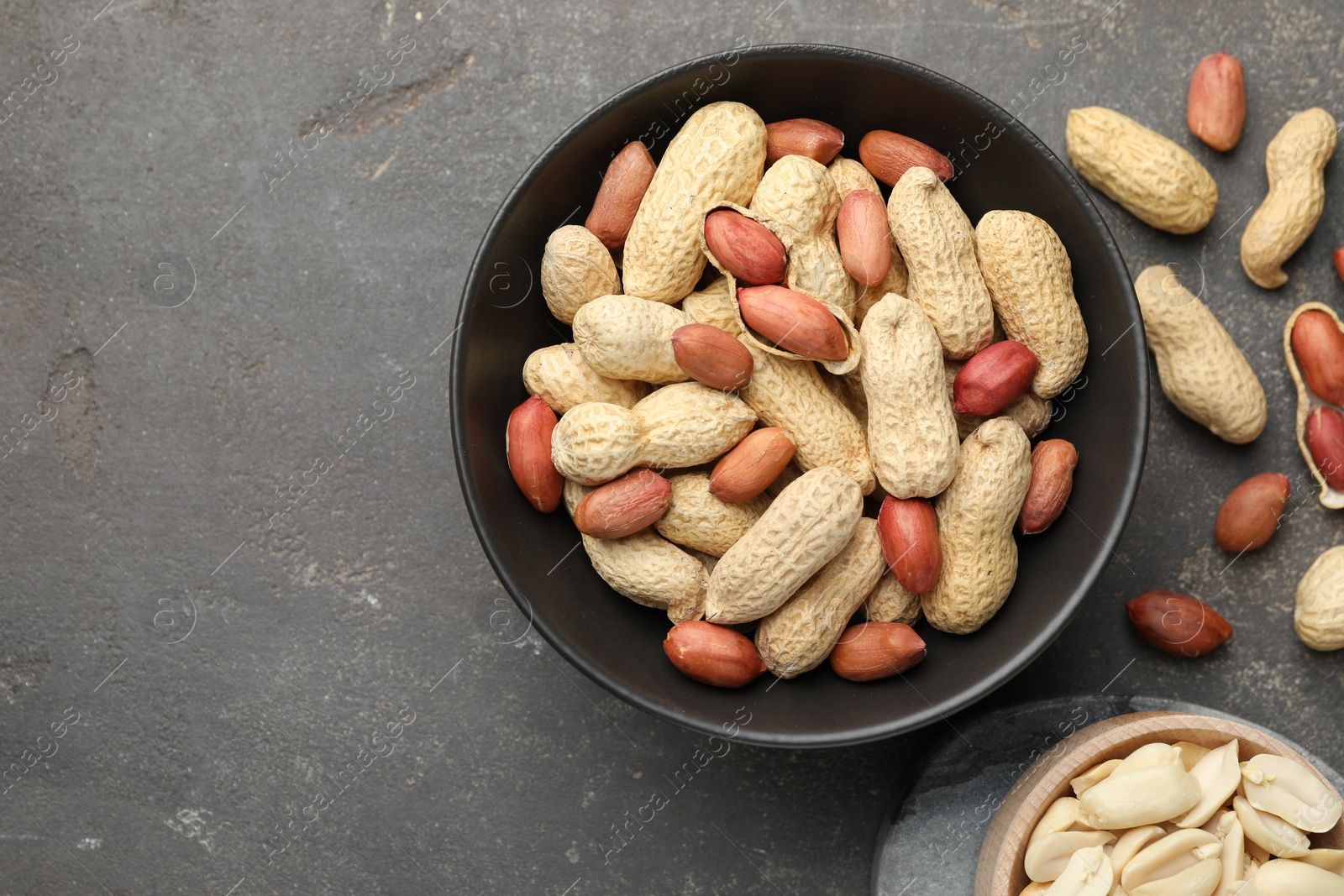 Photo of Fresh peanuts on grey table, top view. Space for text