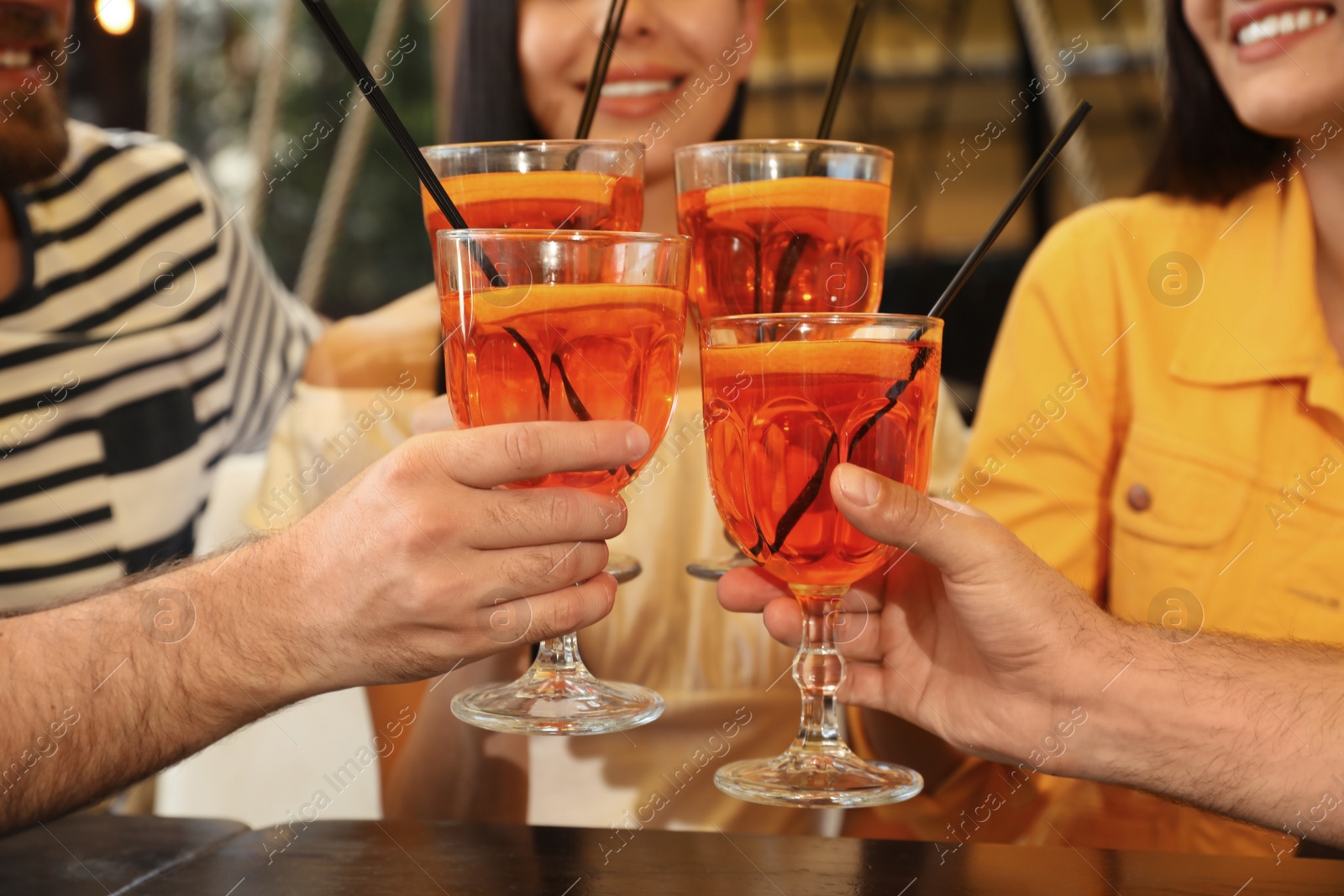 Photo of Friends with Aperol spritz cocktails resting together at restaurant, closeup